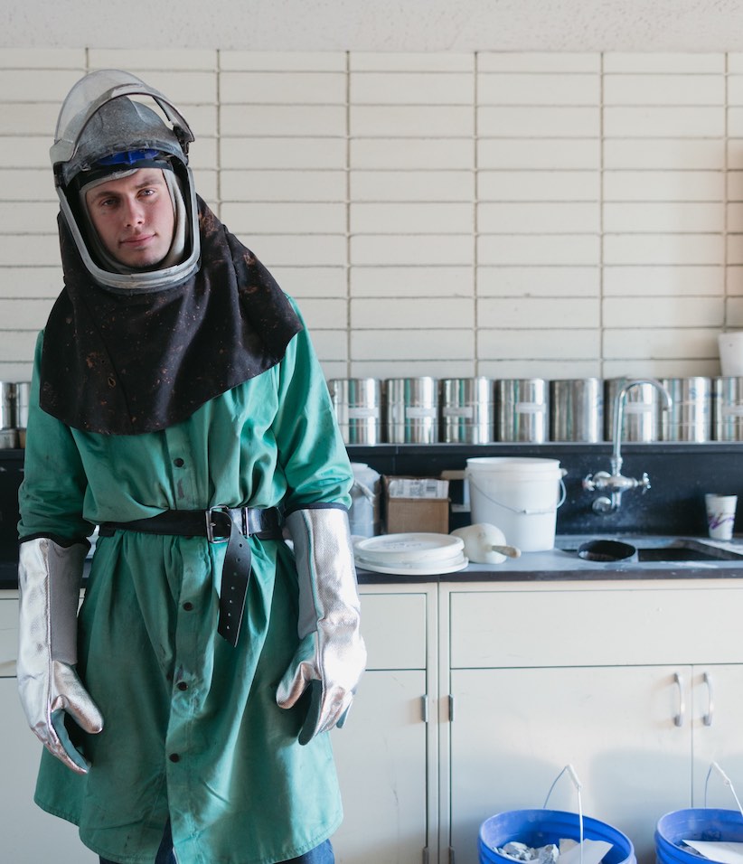 Person im Chemikalienschutzanzug in einem Labor.